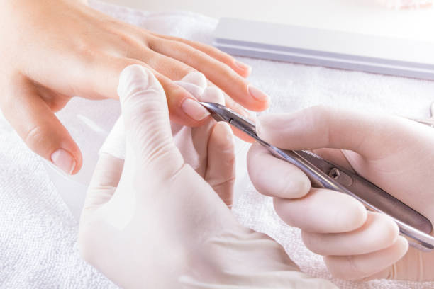The master in the salon makes the client a manicure. Closeup finger nail care by manicure specialist in beauty salon. Manicure clear cuticle professional nippers for manicure. cuticle photos stock pictures, royalty-free photos & images