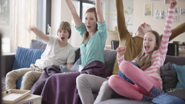 Family cheering in front of TV