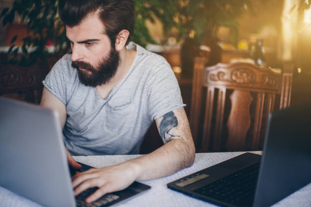 istock Handsome man working on laptop in living room 660751368