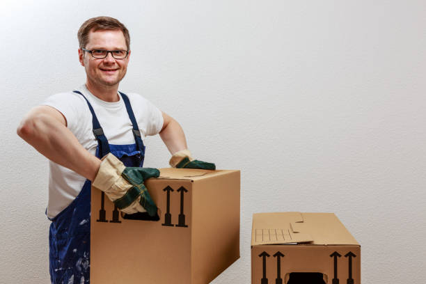 Man lifts heavy boxes stock photo