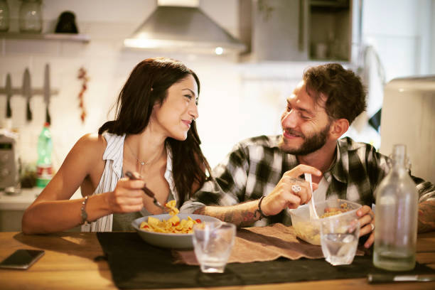 istock Young couple eating together at home 660754198