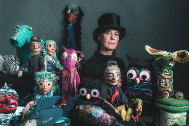 istock Puppeteer standing between handmade puppets. 660758154