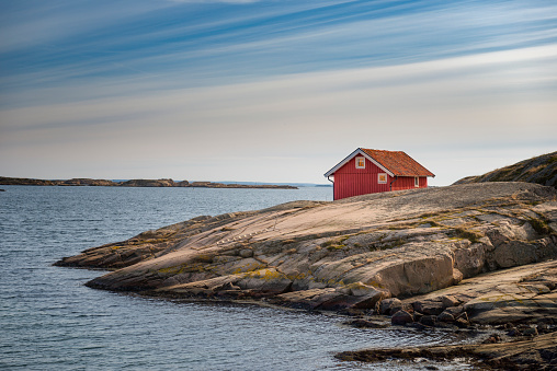 Red cottage on a remote location in the Swedish archipelago. Bohuslan, Sweden.