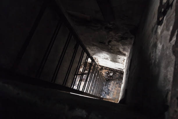 istock Rusted metal ladder going down from dark room 660771834