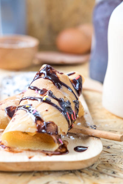 istock roll pancake filling with cream and topping with chocolate sauce 660775744