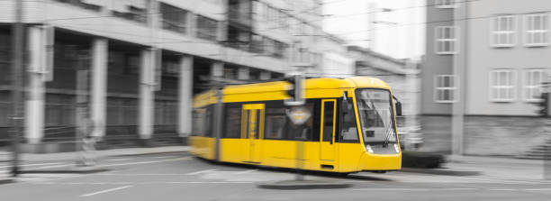istock speeding yellow tram with black and white city background 660775922