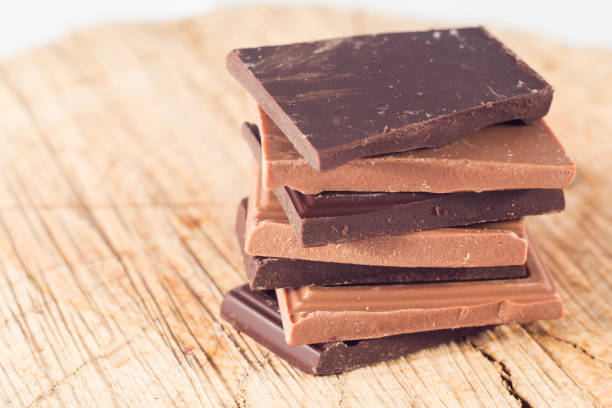 istock Milk and dark chocolate pyramid on wooden table. 660778956