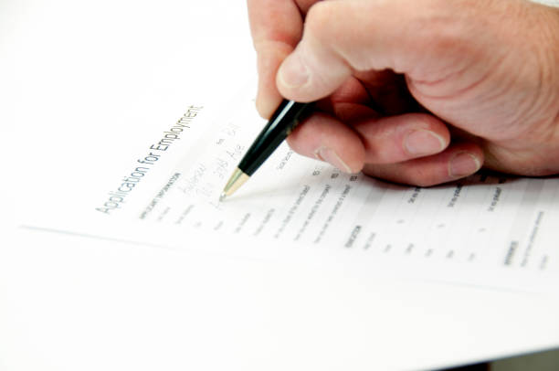 istock Filling out an application for employment  hand only 660782596