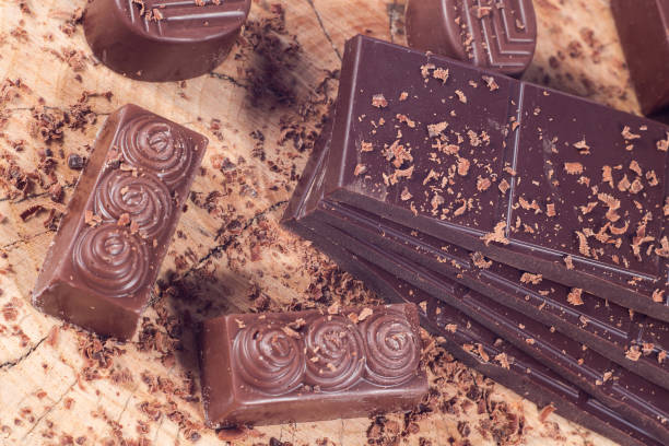istock Dark chocolate on wooden table. Chocolate crumb 660785128