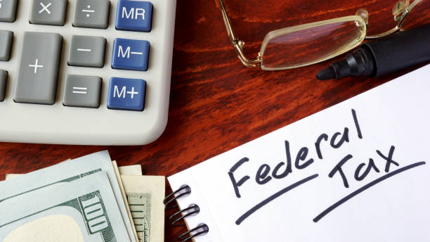 istock Federal tax written in a notebook and calculator. 660826304