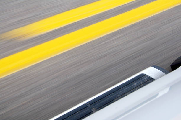 Blurred Lines on Highway Yellow lines blur beside this moving vehicle running board stock illustrations