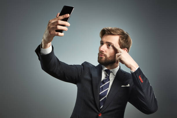 istock A man in a business suit with a smartphone is making a selfie. 660844320