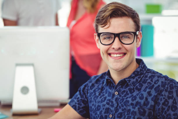 istock Smiling creative businessman working near co workers 660855010