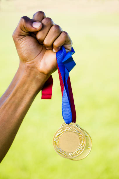 istock Athletes hand holding gold medal after victory 660855684
