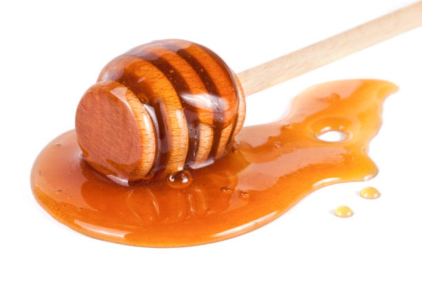 istock Honey stick with flowing honey isolated on white background 660869542