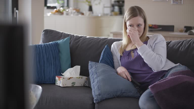 Woman crying while watching a movie on the sofa