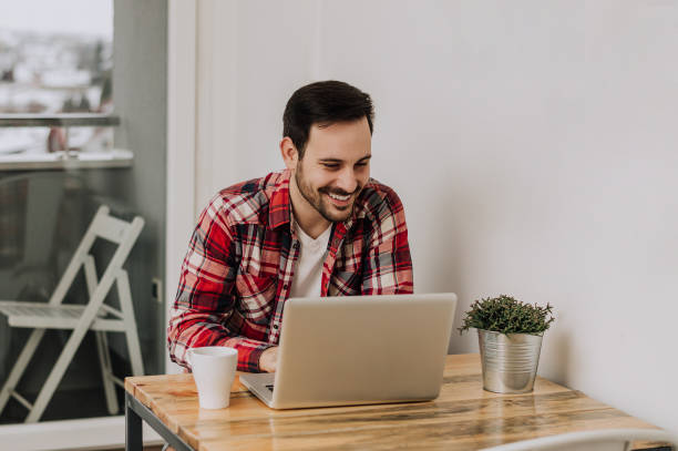 istock Confident expert at work. Handsome man using his laptop while sitting at his working place 660892946