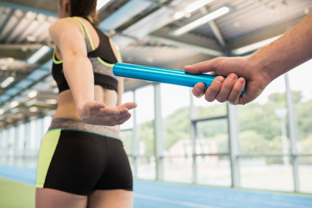istock Man passing the baton to partner on track 660908250