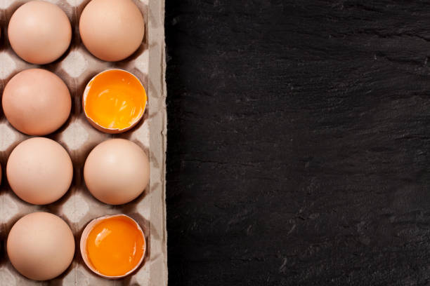 istock eggs in a tray on a dark background with copy space for your text. Top view 660908278