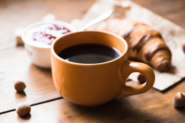 istock Coffee croissant on old wooden table background 660928218