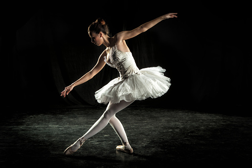 Ballerina performing on dark stage