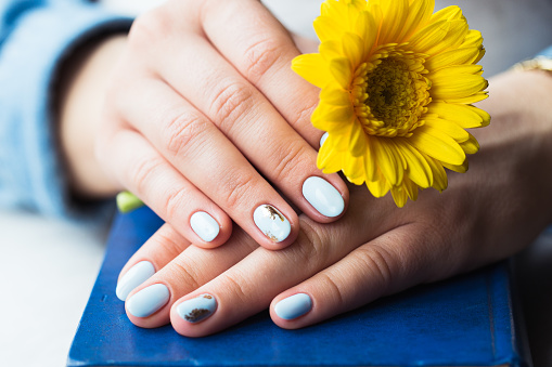 Girl's hands on a book with a yellow flower