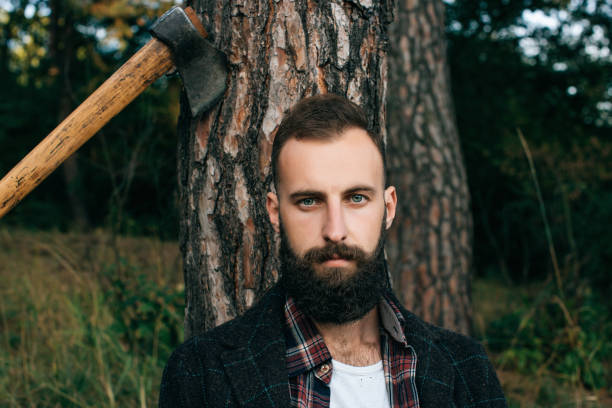istock woodcutter hipster Gypsy man in the forest with ax 660945202