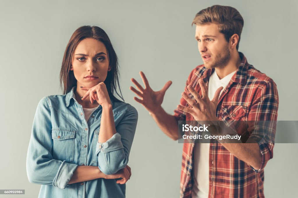 Young couple having a quarrel Young couple having a quarrel. Girl is looking at camera while guy is scolding her Arguing Stock Photo