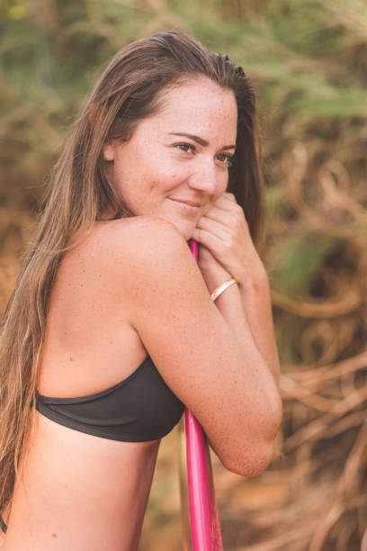 istock Fit young Eurasian woman poses with surfboard on Hawaii beach 660961104