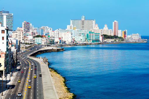 View over the famous seaside promenade Malecon with skyline of modern Havana with hotels is visible in the background, elevated view, long exposure