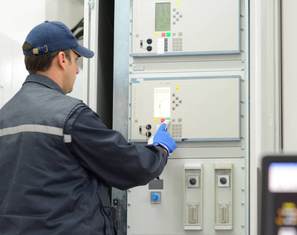 istock Tehnician with red hardhat testing equipment in electrical room 660993104