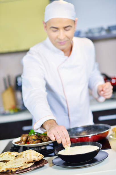 istock mature chef preparing a meal with various vegetables and meat 661000592