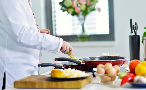 istock mature chef preparing a meal with various vegetables and meat 661013780