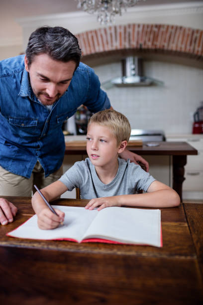 istock Father helping son with his homework in kitchen 661029852