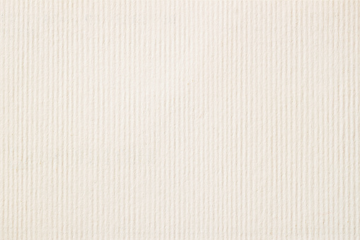 Texture of cream-coloured pastel paper with small inclusions for watercolor and artwork. Modern background, backdrop, substrate, composition use with copy space