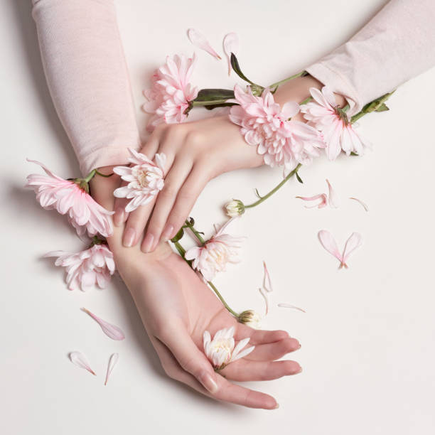 moda arte retrato mujer en vestido de verano y las flores en la mano con un maquillaje de contraste brillante. chicas de foto creativa belleza sentada en el fondo de la tabla en una contrastadas rosa con sombras de colores - floral dress fotografías e imágenes de stock