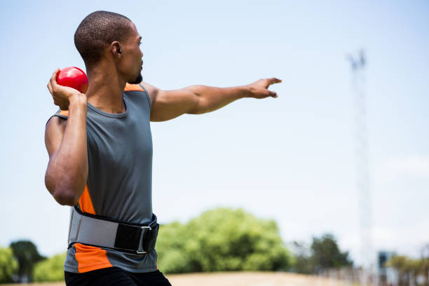istock Male athlete about to throw shot put ball 661048032