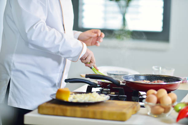 istock mature chef preparing a meal with various vegetables and meat 661056310