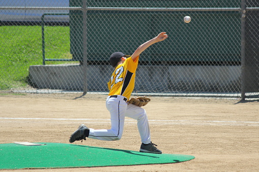 A young boy pitching a strike in a baseball game.