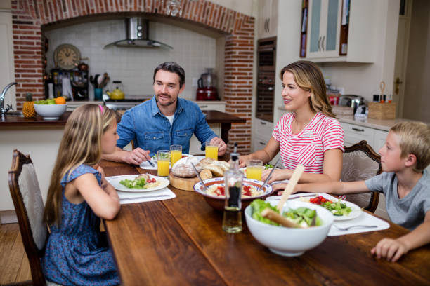 istock Happy family talking to each other while having meal in kitchen 661066420