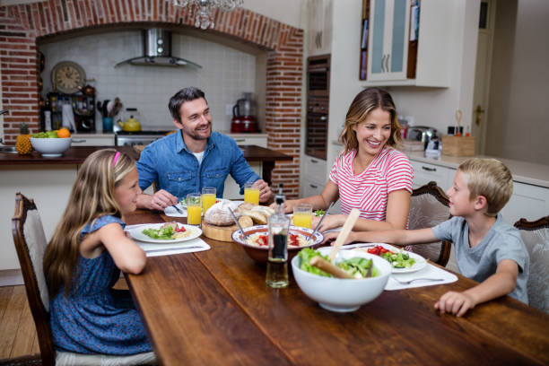 istock Happy family talking to each other while having meal in kitchen 661066846