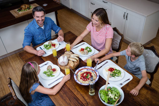 istock Happy family talking to each other while having meal in kitchen 661073714