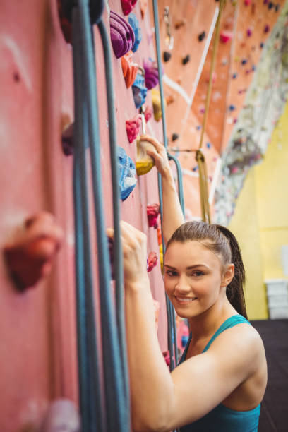 istock Fit woman rock climbing indoors 661097384