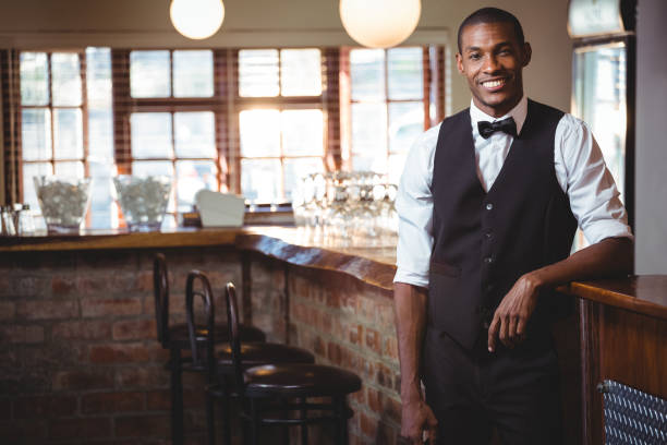 istock Portrait of bartender standing at bar counter 661120402