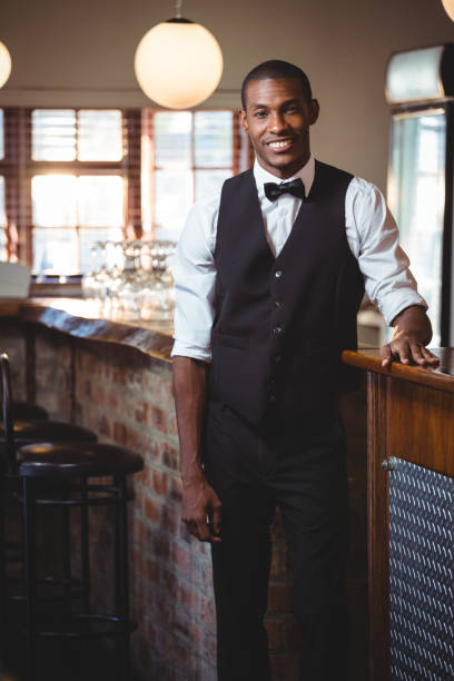 istock Portrait of bartender standing at bar counter 661120602