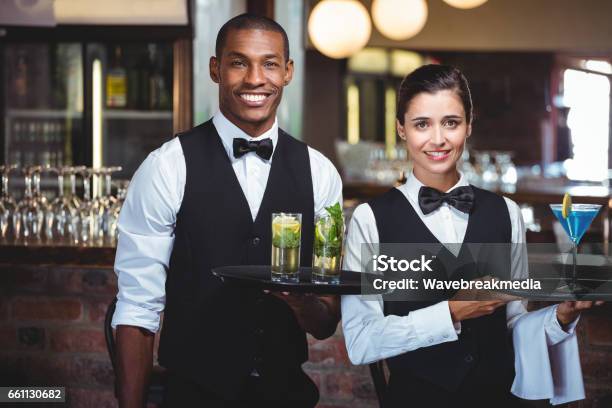 Waiter And Waitress Holding A Serving Tray With Glass Of Cocktail Stock Photo - Download Image Now