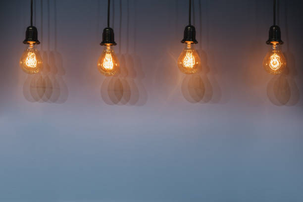 istock Decorative antique edison style light bulbs against wall background. 661183686