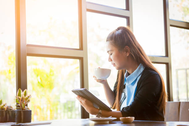 istock Young woman is drinking coffee with using tablet in coffee shop 661202556