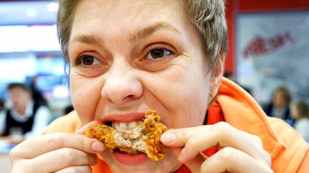 istock Young woman eats fast food in cafe restaurant 661211716