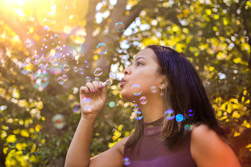 Latina Girl Blowing Bubbles Outdoors